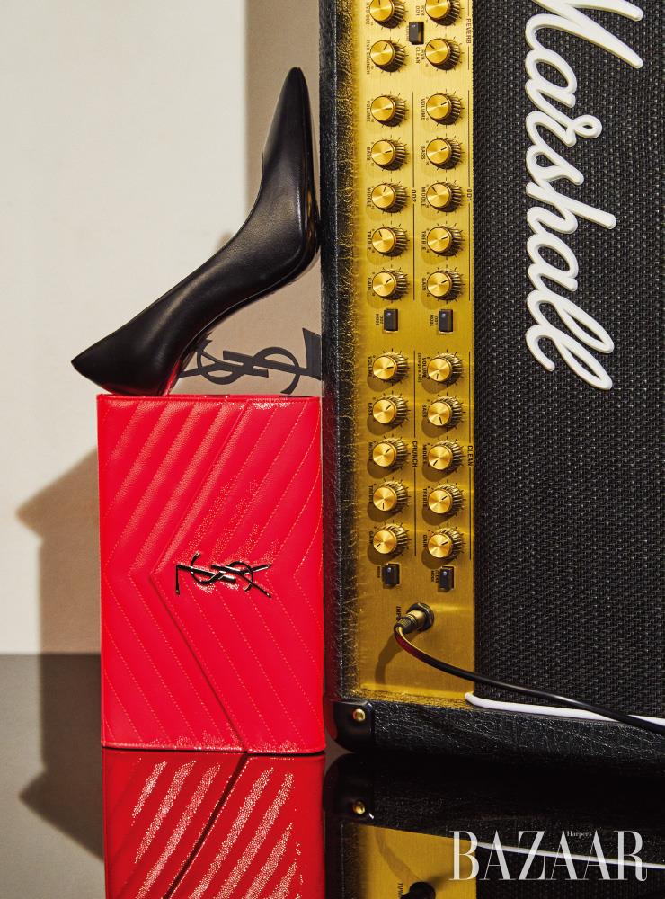 매트한 올 블랙의 ‘오피움’ 펌프스, 네온 핑크 컬러의 지갑은 모두 Saint Laurent by Anthony Vaccarello. 