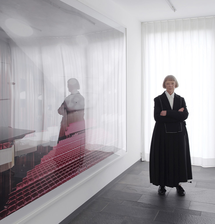 디자이너?질 산더(Jil Sander) 의 외투를 입고 자신의 작품이 걸려있는 사옥 응접실에서 포즈를 취한 칸디다 회퍼.