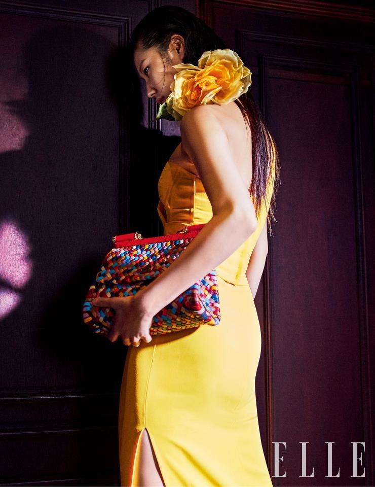 과감한 커팅이 돋보이는 원 숄더 옐로 드레스와 플라워 초커, 멀티 컬러 위빙으로 완성한 ‘인트레치오 시실리’ 백은 모두 Dolce & Gabbana.