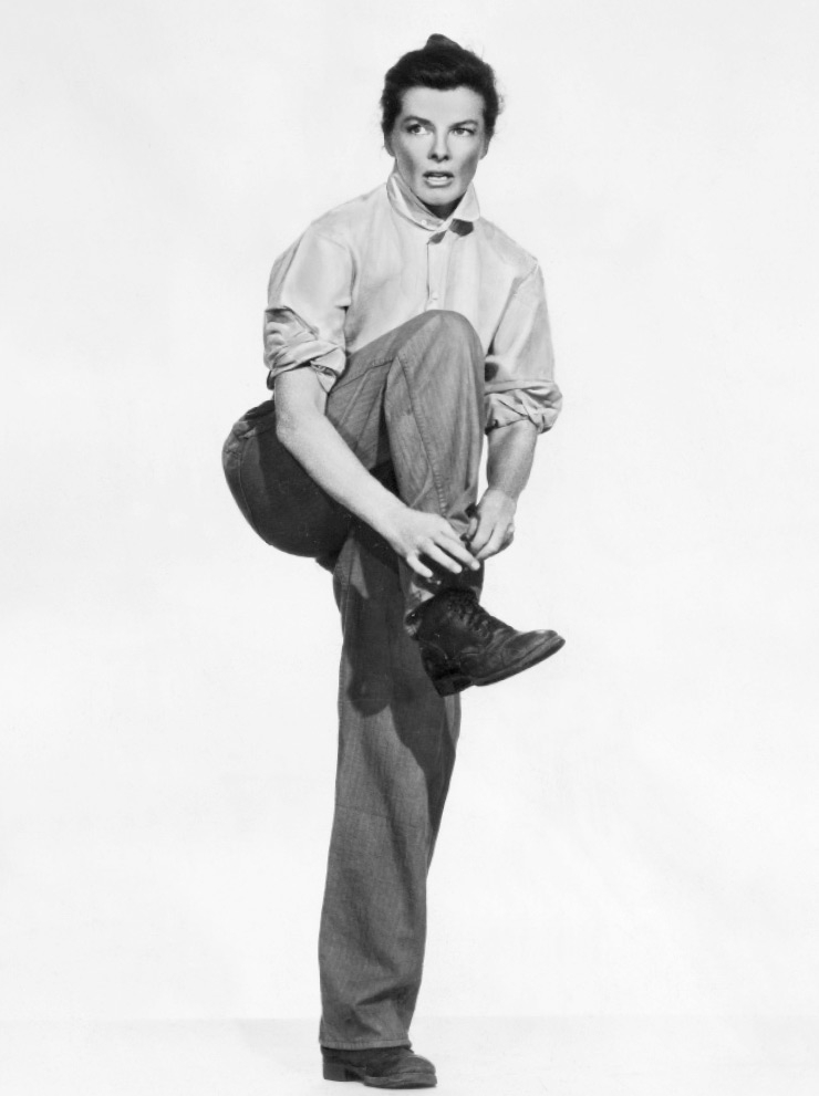 1956년, 오버사이즈 셔츠에 와이드 레그 진, 매니시한 레이스업 부츠를 신고 포즈를 취한 캐서린 헵번.
