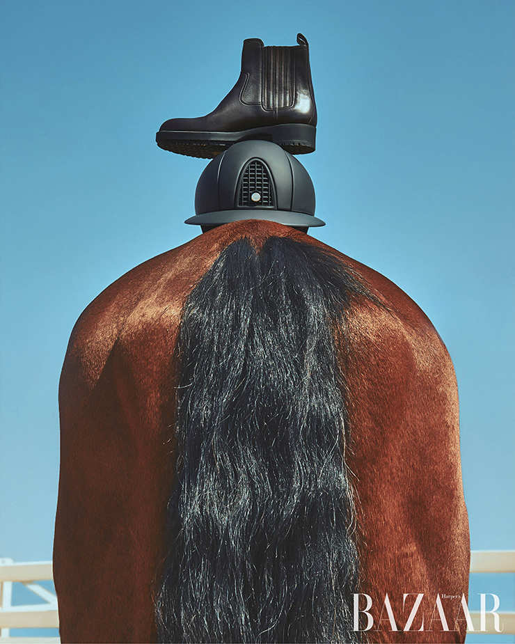 방수 기능의 카프 스킨과 러버 솔로 만든 승마용 앵클부츠, 턱 끈과 와이드 폴로 바이저가 장식된 충격 흡수 기능의 폴리카보네이트 소재 승마용 헬멧은 Hermès.