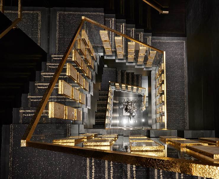 계단의 투명한 난간은 크리스털과 금동 직사각 카보숑으로 장식했다. 계단 아래에는 조엘 모리슨(Joel Morrison)이 부티크의 리오프닝을 위해 특별히 제작한 현대적인 실버 스틸 조각 ‘코코 샹들리에(Coco Chandelier)’.