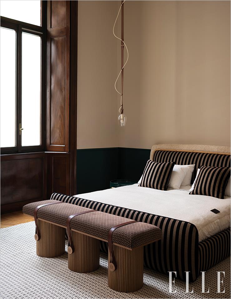 펜디의 상징적인 페퀸 줄무늬로 장식된 침대가 시선을 사로잡는 펜디 카사 아파트 침실.