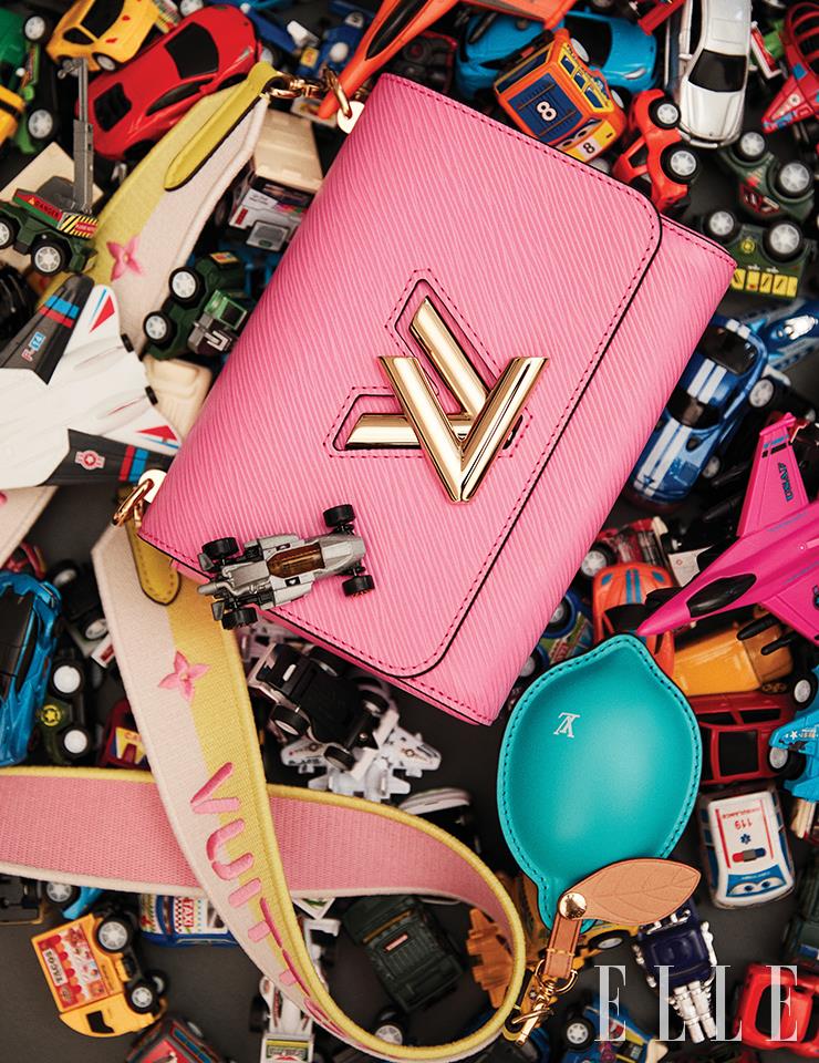 스포티 무드의 스트랩과 동전지갑으로 활용 가능한 귀여운 레몬 참 장식, 클래식한 가방 실루엣이 조화로운 트위스트 MM 핸드백은 Louis Vuitton.