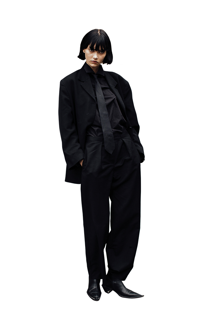 재킷부터 셔츠, 팬츠, 넥타이까지 매니시한 올 블랙 수트 룩을 선보인 모델 소피아 스타인버그.