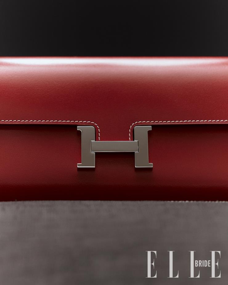 붉은빛의 선명한 컬러감이 시선을 사로잡는 클러치 겸 지갑은 Hermès. 스티치 장식의 모시 소재 방석은 Et Cetera. 
