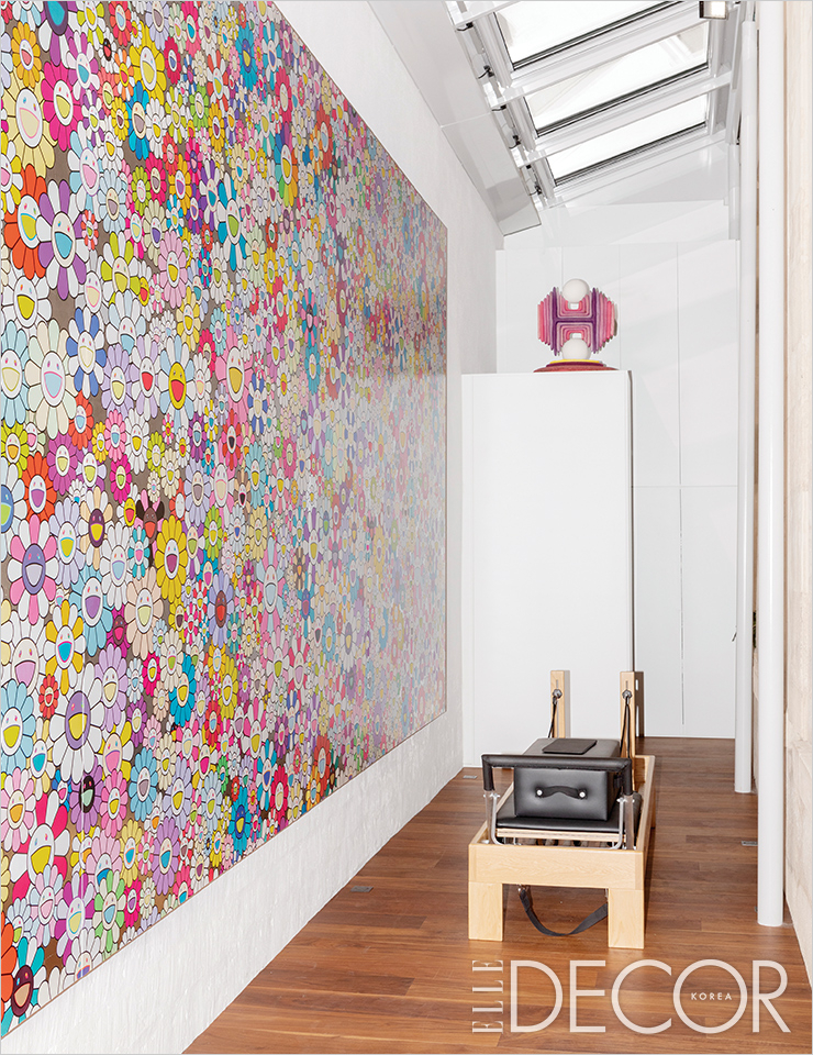 한 벽 가득 무라카미 다카시의 〈Untitled〉(2018)가 걸려 있는 피트니스 룸. 선반 위에 놓인 작품은 매튜 로네이의 〈Double Orbing Fields〉(2015).