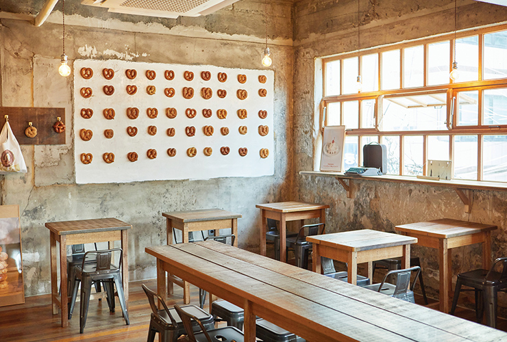 콘크리트 벽면과 따뜻한 우드 계열이 조화를 이루는 브레디포스트의 실내.