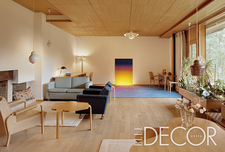 핀란드 목재로 제작한 천장과 파노라믹 전경이 투영된 거실 풍경.