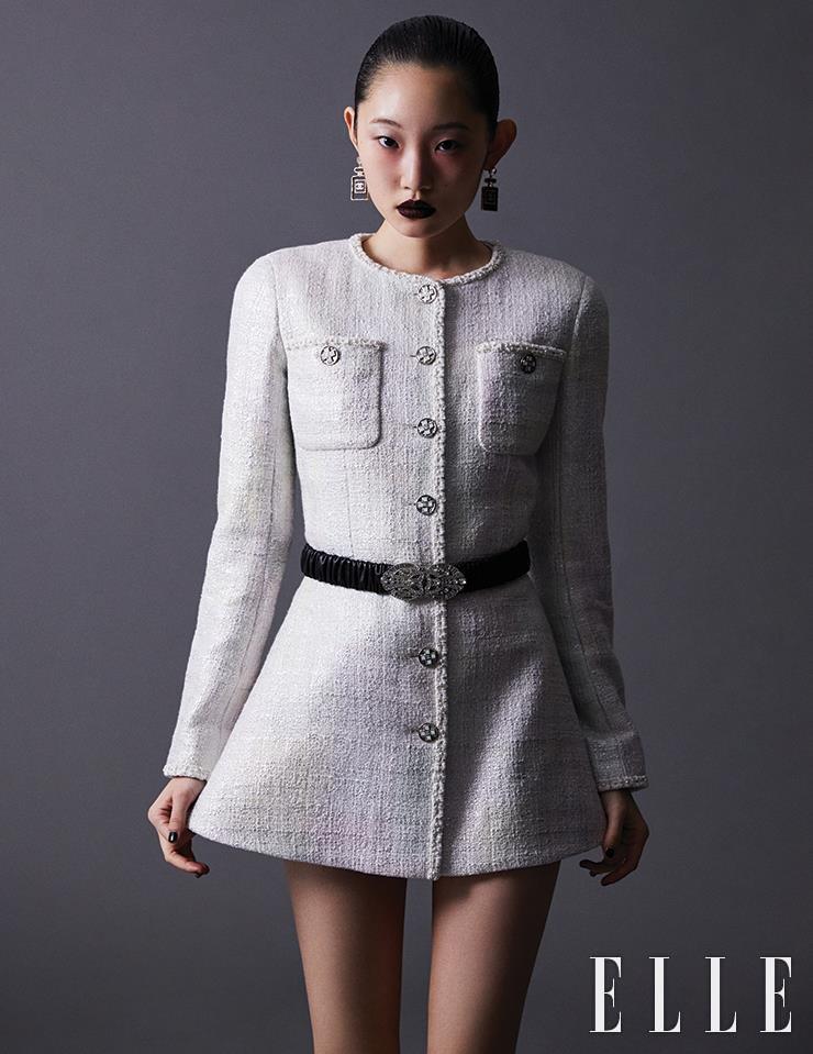 화이트 브리드와 볼드한 버튼이 특징인 페인티드 코튼 판타지 트위드 재킷과 향수병 모티프의 이어링, 셔링 장식의 벨트는 모두 Chanel.
