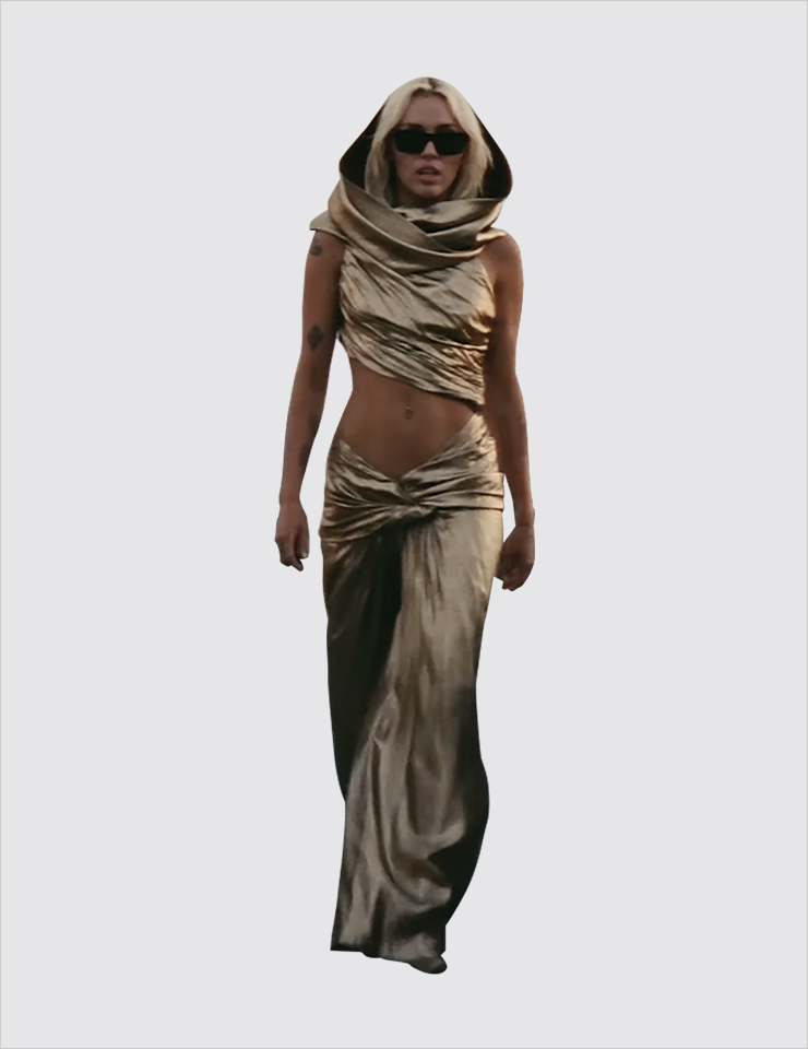마일리 사이러스의 신곡 ‘Flowers’ 뮤직비디오에 나타난 1991년의 생 로랑 아카이브 피스. 생 로랑 2023 S/S 시즌에 유려한 후디드 실루엣의 드레스가 등장하는 가운데 유일무이한 그녀의 메탈릭 골드 드레스가 빛을 발했다. 