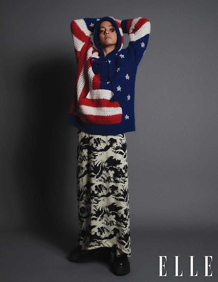 Hooded Knit Top with American Flag Pattern, Maxi Skirt with Palm Tree Pattern, and Bulky Ankle Boots are all from Celine Homme.